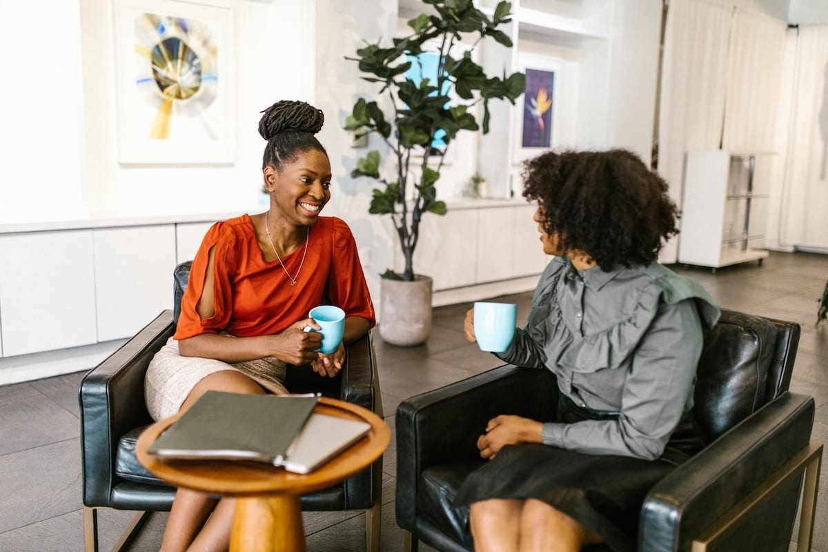 Two colleagues having a conversation over a coffee